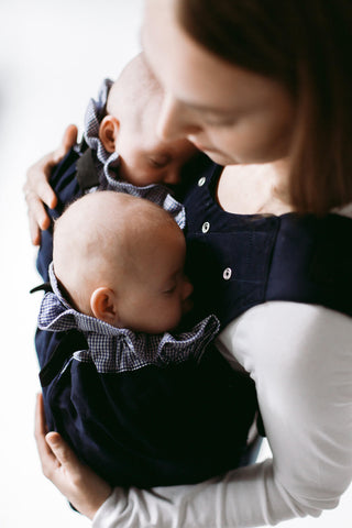 Woman carrying twins in Weego TWINS baby carrier. View from top-right.